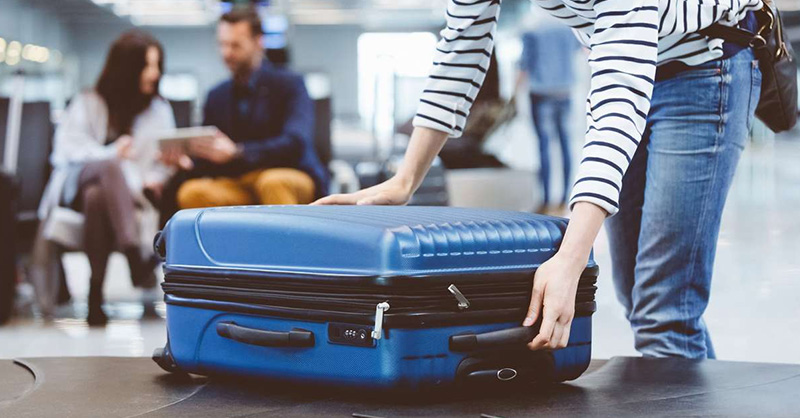 une personne tenant une valise, bagage pour partir en voyage